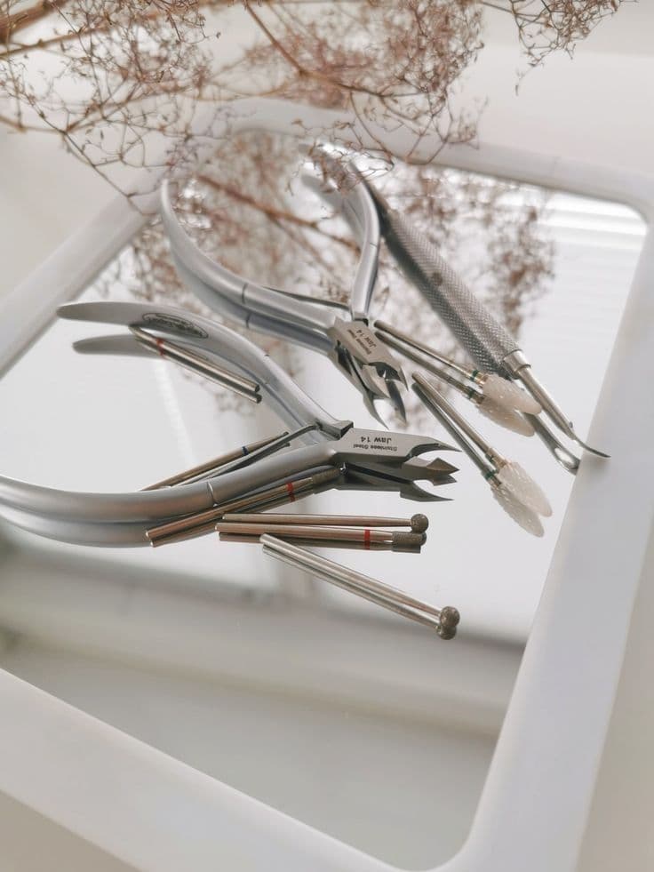 Elegant nail tools arranged with delicate flowers, creating a calm and aesthetic composition